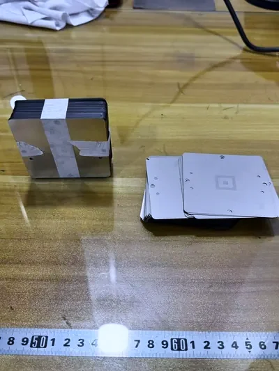 Small fine-pitch BGA stencil foils laid out on a work bench with a steel rule