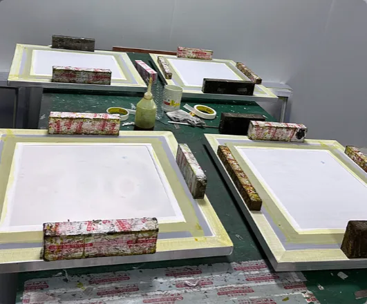 Framed stencils taped down on the fitting bench
