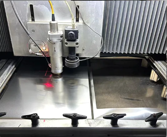Fiber laser cutting head cutting a stainless steel stencil sheet