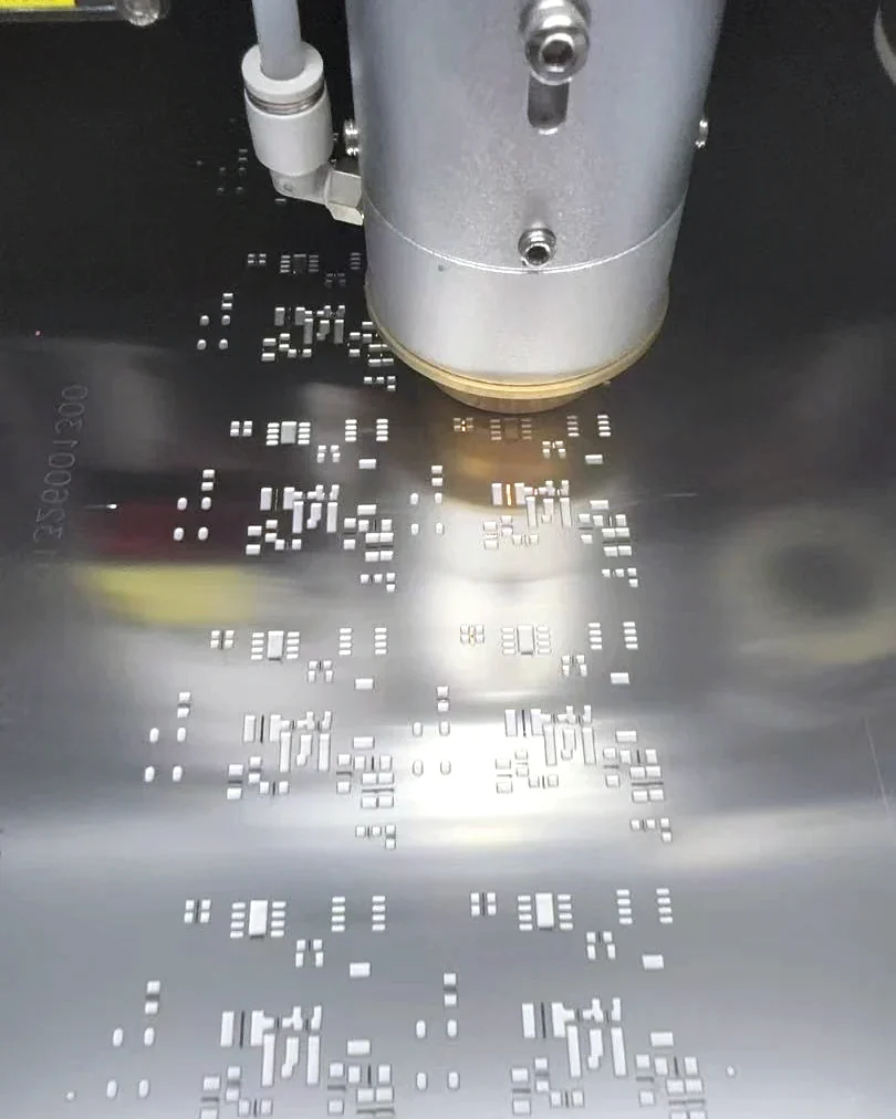 Fiber laser cutting head cutting apertures into a stainless steel SMT stencil